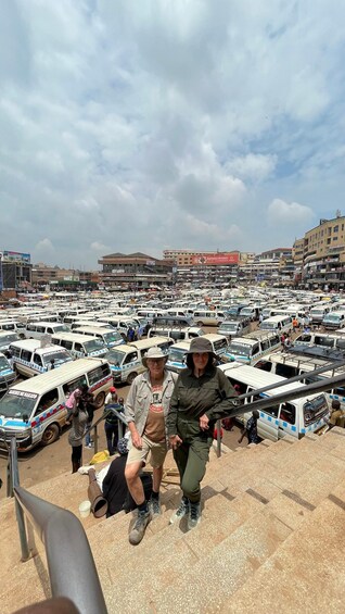 A busy parking lot with numerous white minibuses and a few people walking. 3