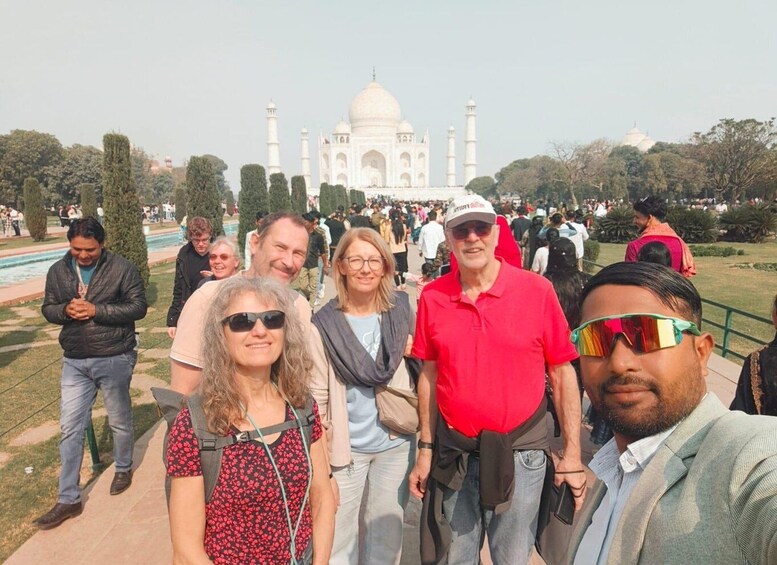 A group of people standing in front of the Taj Mahal. 4