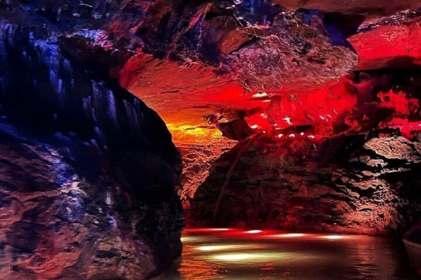 A cave with red lighting and a water pool. 5