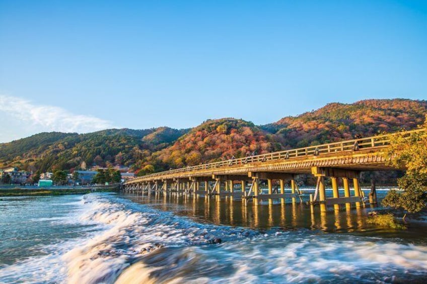 A bridge over a river with autumn foliage on the hills. 5