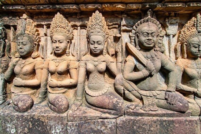 A stone carving of three seated figures with elaborate headdresses and jewelry. 5