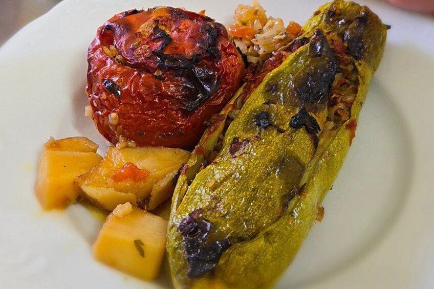 Un piatto con verdure arrostite, tra cui un pomodoro rosso, una zucchina verde e patate a cubetti. 5