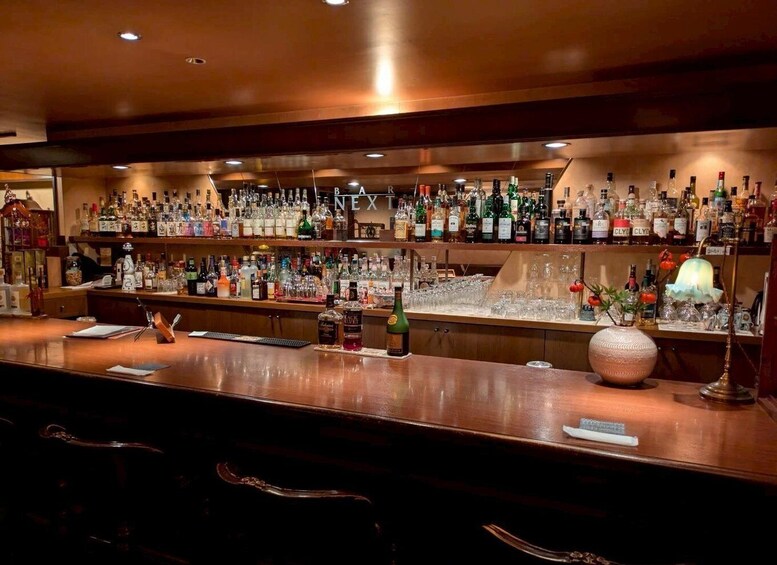 Un bar où l’on trouve une grande variété de bouteilles d’alcool et de verres. 5