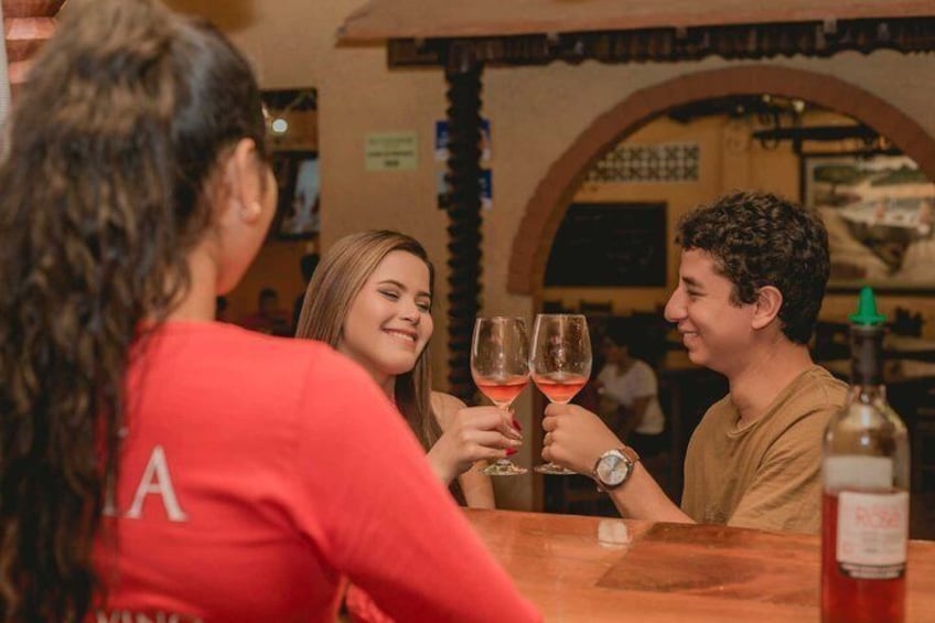 En grupp människor som skålar med vinglas på en bar. 5
