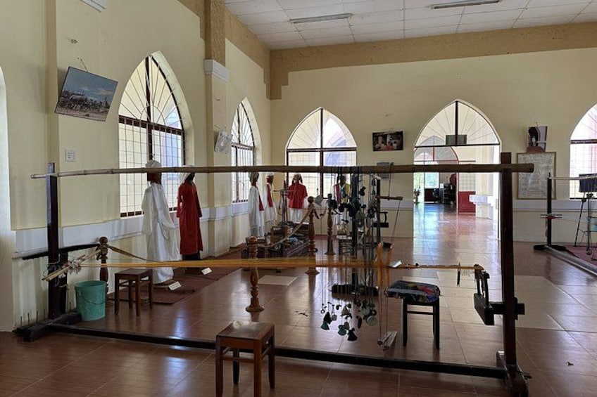 A room with arched windows, a wooden floor, and a group of people in traditional attire. 3