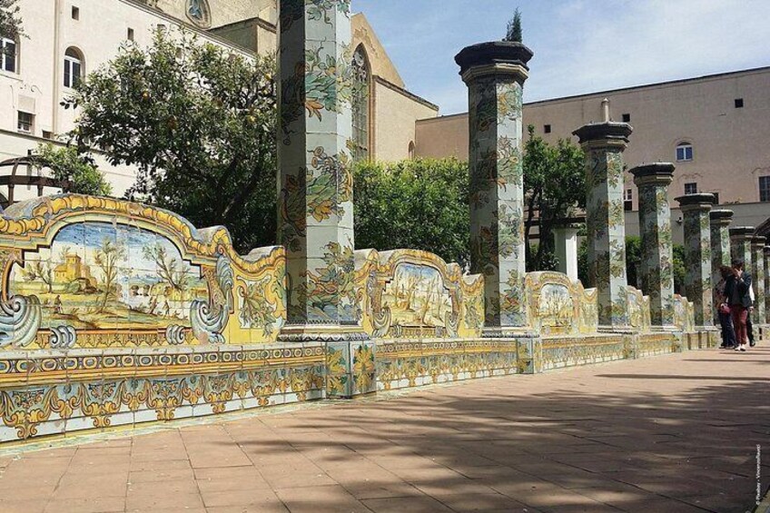 A tiled walkway with ornate columns and a decorative wall. 4