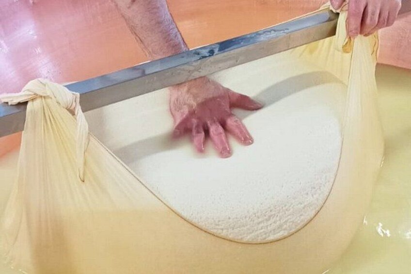 En person som hanterar ett stort, runt, vitt föremål i en gulaktig vätska. 2