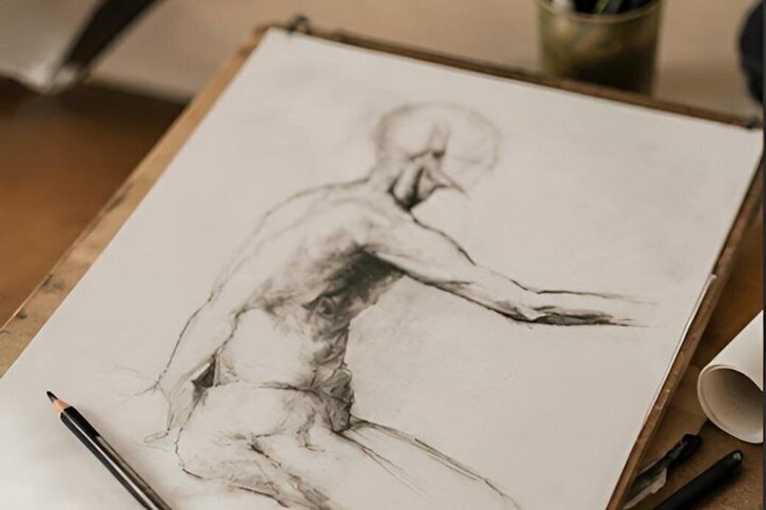 Un croquis d’une silhouette humaine sur une planche à dessin, avec un crayon et une tasse de café à proximité. 1