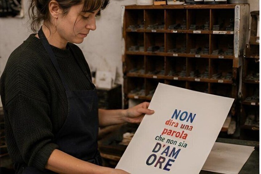 A person holding a sign with text in a workshop setting. 2