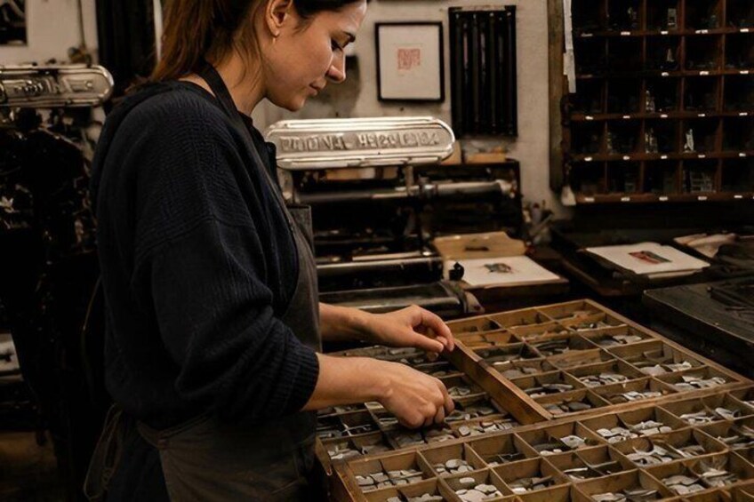 A person organizing small objects in wooden trays in a workshop with vintage equipment. 5