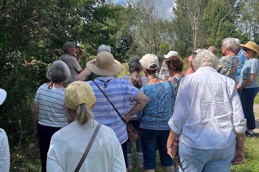 Un groupe de personnes se tient à l’extérieur, peut-être sur un sentier ou dans un parc. 2