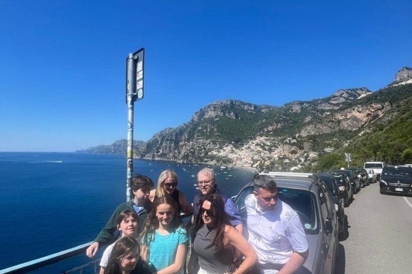 A group of people on a boat with a mountainous coastline in the background. 4
