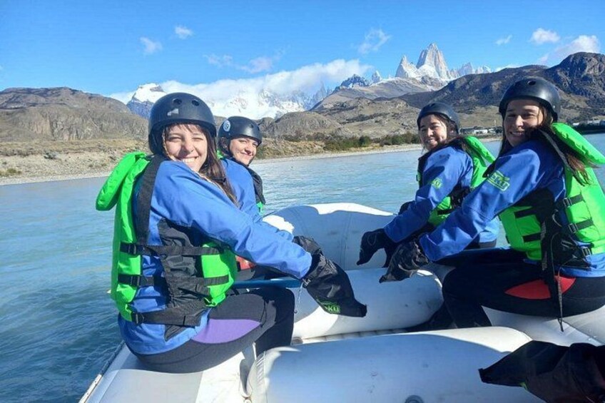 Un grupo de personas en un barco con un paisaje montañoso al fondo. 1