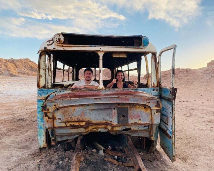 A rusted, abandoned vehicle in a barren landscape. 5