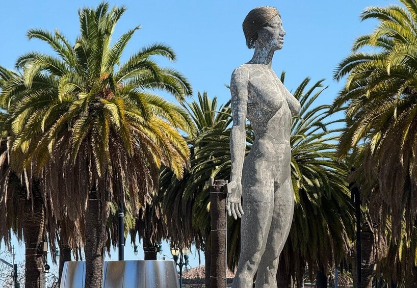 A statue of a woman in a tropical setting with palm trees. 5