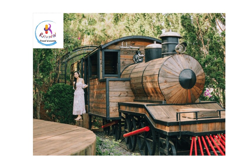 A wooden train with a woman standing on the platform. 5