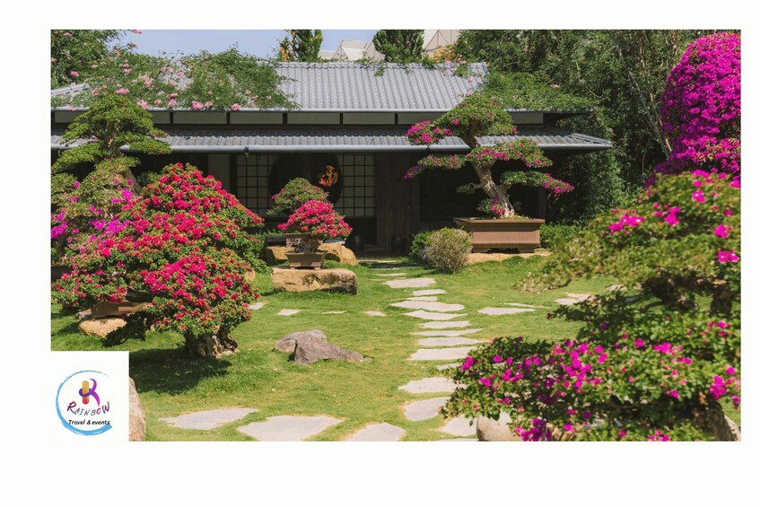 A traditional Japanese garden with a stone pathway, vibrant pink flowers, and a bonsai tree. 3
