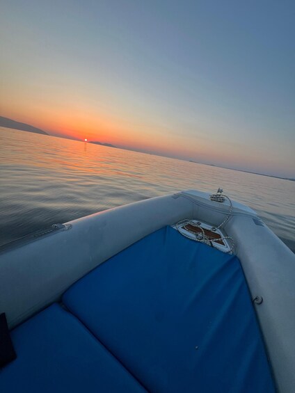 A boat's interior with a blue cushion and a small window. 5