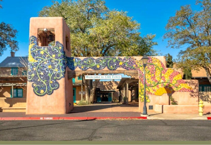 A colorful entrance with a 'Welcome to Old Town' sign, a decorative archway, and a building with a tiled facade. 3