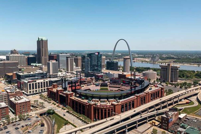 A cityscape with a prominent stadium, high-rise buildings, and a river. 1