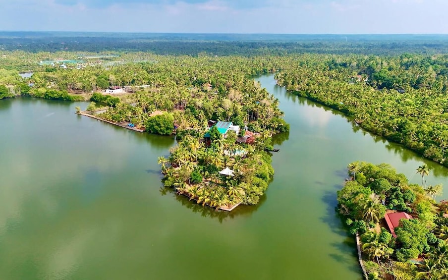 An aerial view of a lush island surrounded by a river, with several buildings and dense vegetation. 4