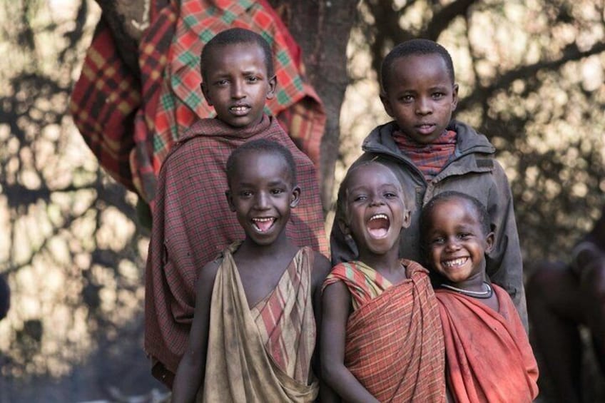 Four children standing outdoors, wearing traditional garments. 5