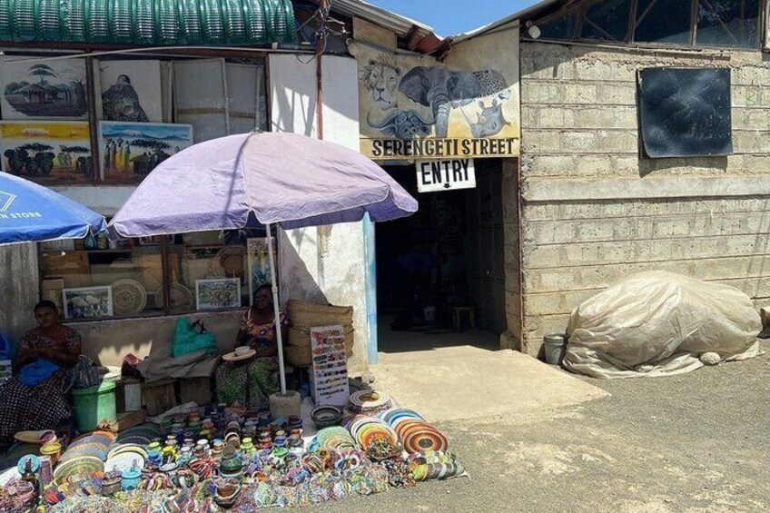 A street vendor stall with colorful items and a sign for Serengeti Street. 2