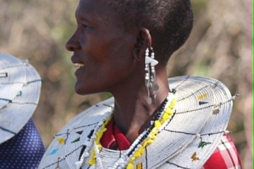 A person wearing a patterned garment with a red shirt underneath. 2