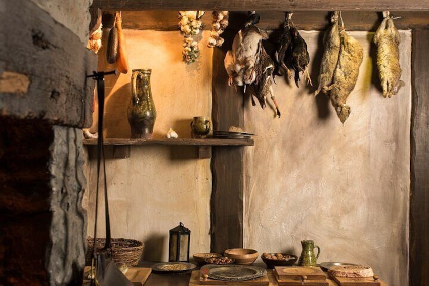 Una cocina rústica con pescado colgando, un jarrón y diversos utensilios de cocina. 5