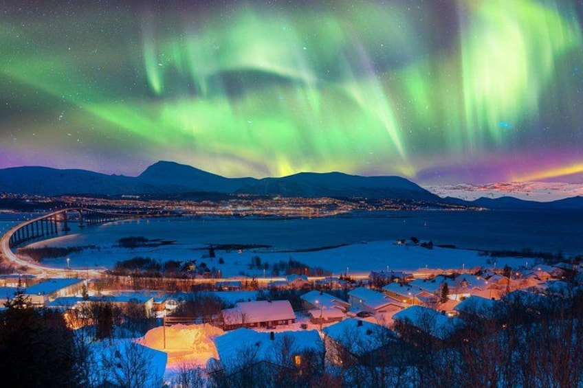 A winter landscape with a bridge, snow-covered houses, and the Northern Lights. 3