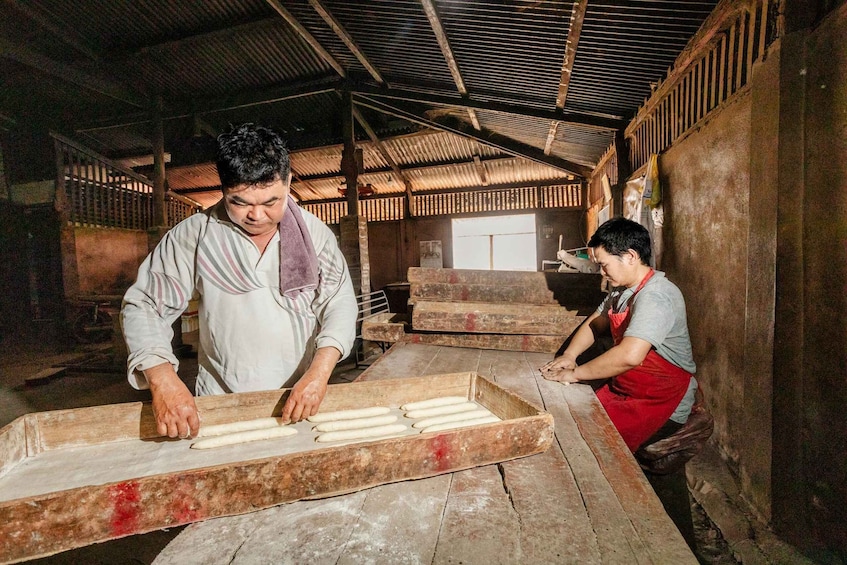 Two people working with dough in a rustic kitchen. 2