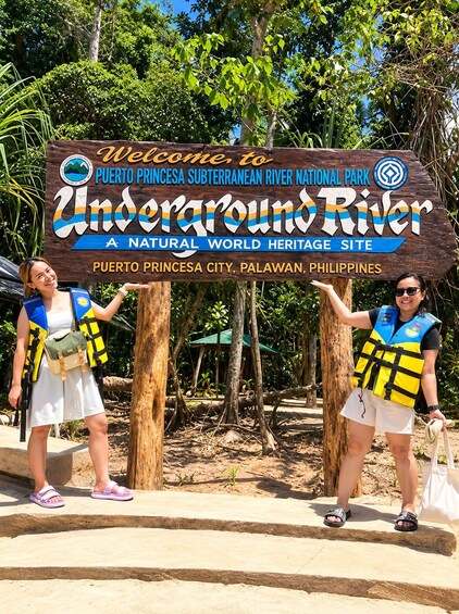 A sign welcoming visitors to the Puerto Princesa Subterranean River National Park, featuring two individuals in life vests. 4