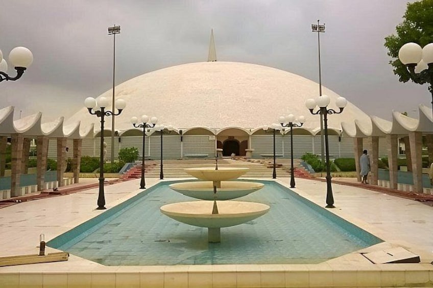 A large fountain with multiple tiers, surrounded by lamp posts and a domed building in the background. 3