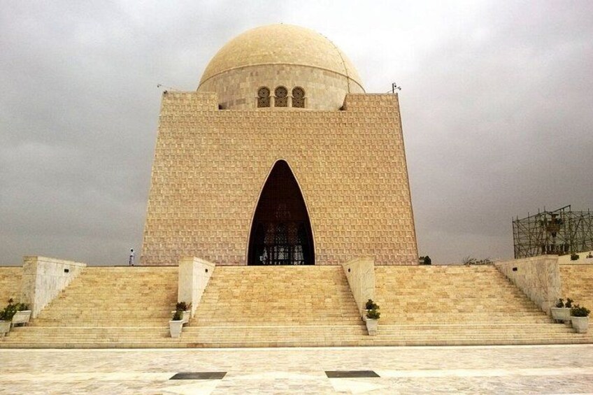 A large, beige-domed building with a central archway and a staircase leading up to it. 5