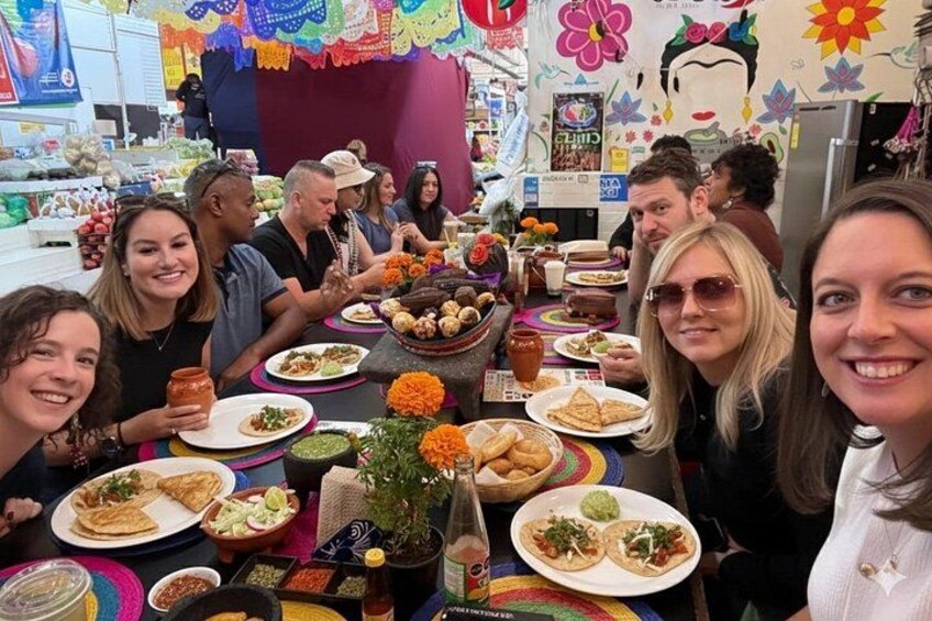 A group of people sitting at a table with various dishes and drinks. 1