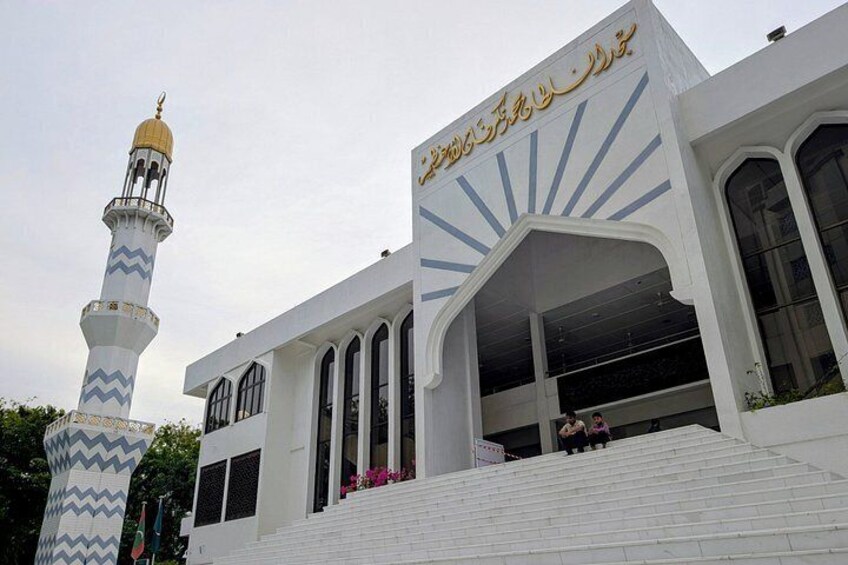A mosque with a minaret and a large arched entrance. 4