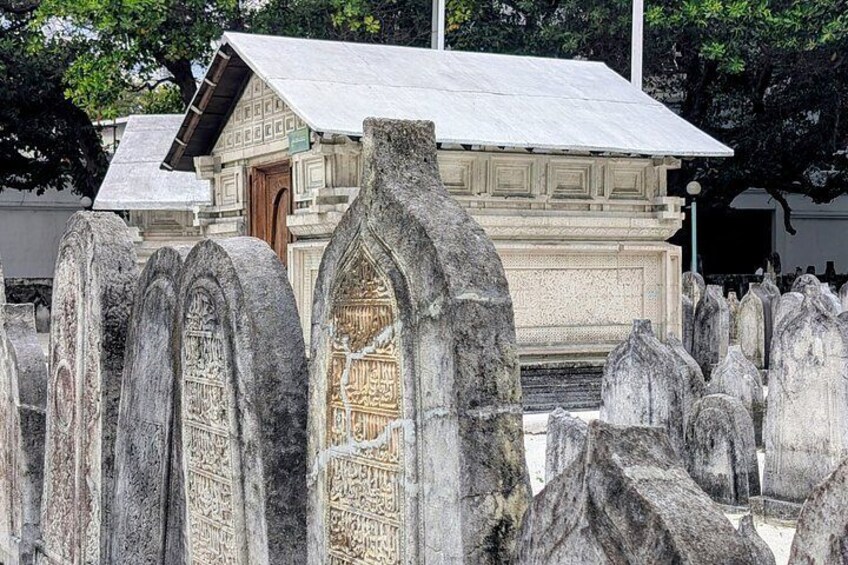 A cemetery with ornate gravestones and a small building with a sloped roof. 5