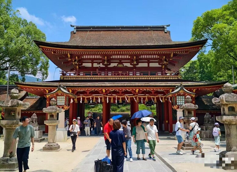 A traditional Japanese gate with visitors walking through. 5