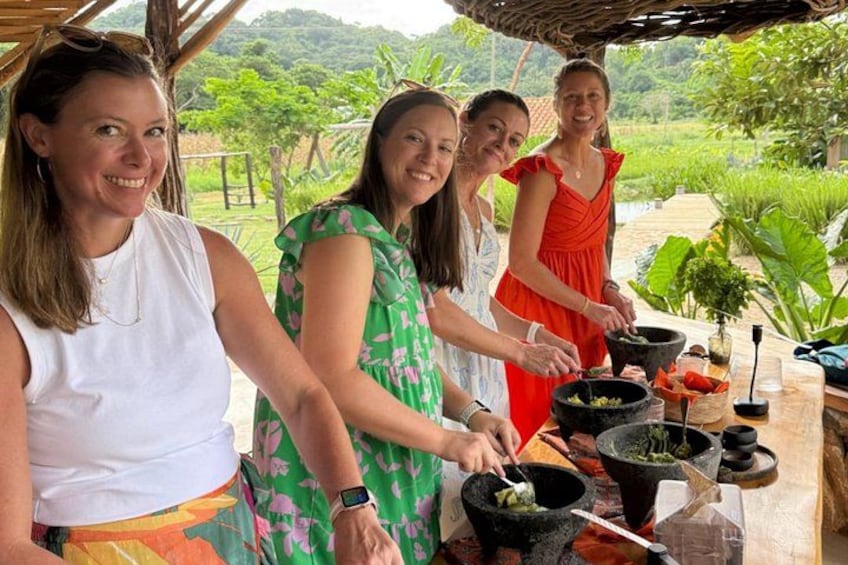 Quattro persone cucinano all'aperto, con un tavolo pieno di utensili e ingredienti. 2