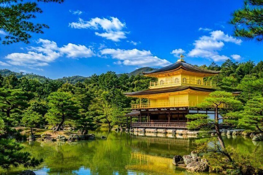 Een traditioneel Japans gebouw met een gouden dak, omringd door een rustig vijver en weelderige begroeiing. 5