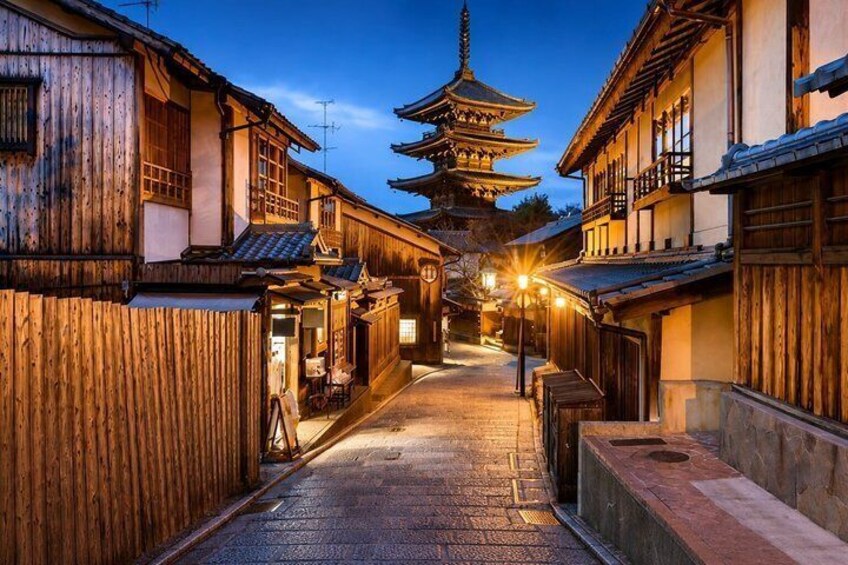 Une rue traditionnelle japonaise au crépuscule, avec des bâtiments en bois, une pagode et des lampadaires. 2