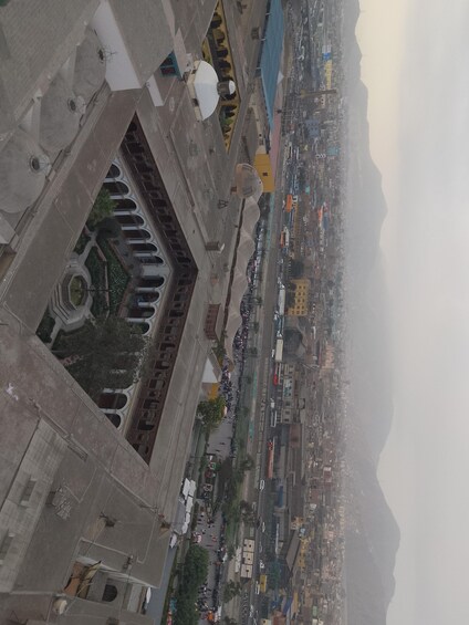 A cityscape with a prominent mosque, a busy street, and mountains in the background. 5
