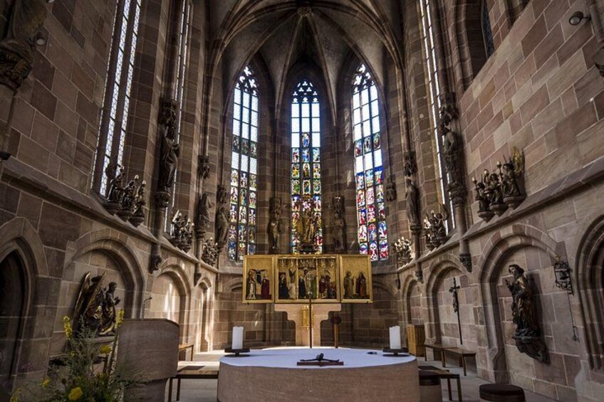 A cathedral interior with stained glass windows, stone arches, and religious statues. 4