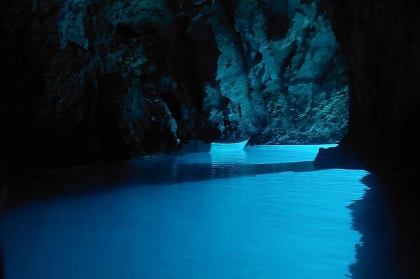 Una cueva con un bote en el agua. 1