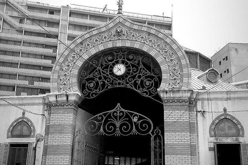 Une photographie en noir et blanc d’un bâtiment doté d’une grande arche ornée et d’une horloge au-dessus. 5