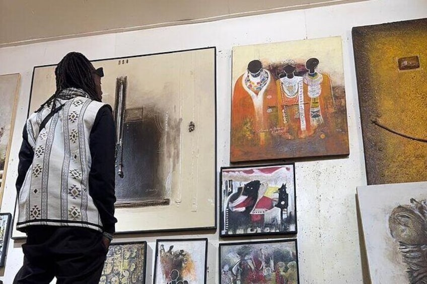 Une personne se tient devant un mur orné de différentes œuvres d’art. 4