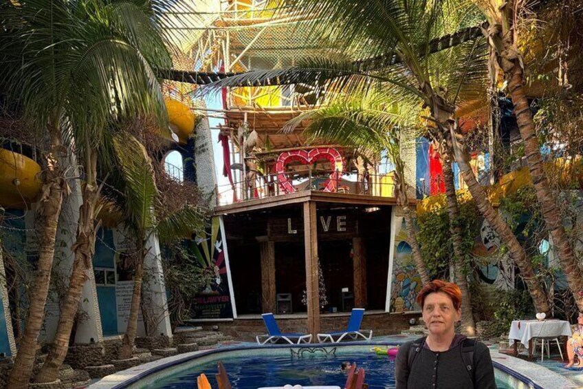 Un espace piscine agrémenté de palmiers, d’une terrasse en bois et d’un panneau sur lequel on peut lire le mot « AMOUR ». 3