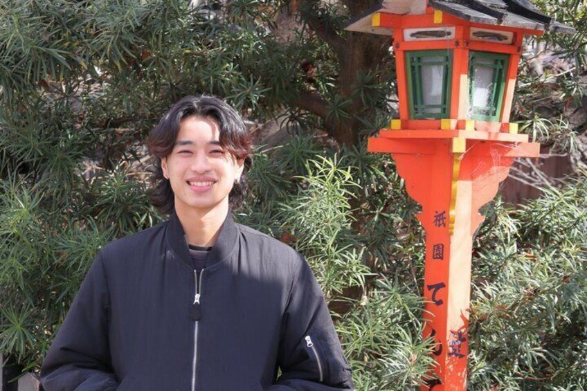 Una persona in piedi di fronte a un tradizionale torii giapponese. 3