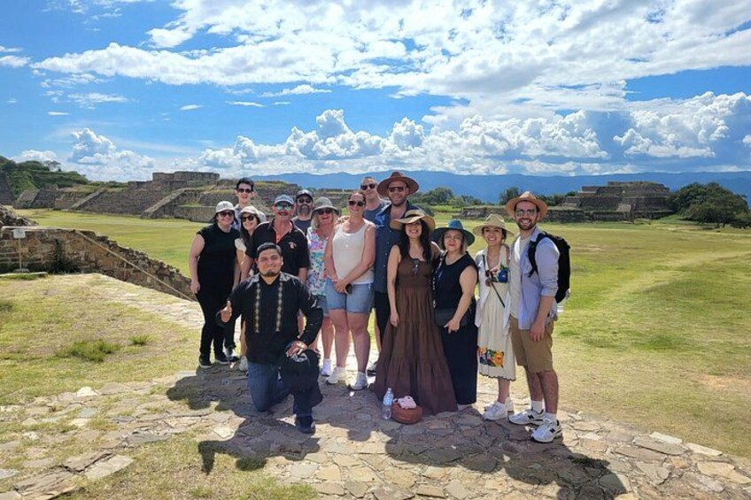 A group of people standing on a stone platform with a historical site in the background. 4