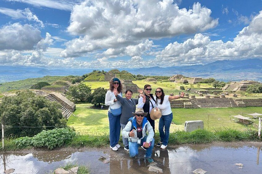 A group of people standing on a wet surface with a historical site in the background. 1